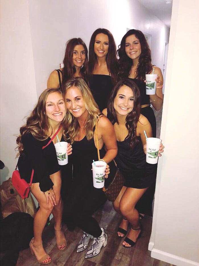 photo of six women wearing black dresses and holding CI cups