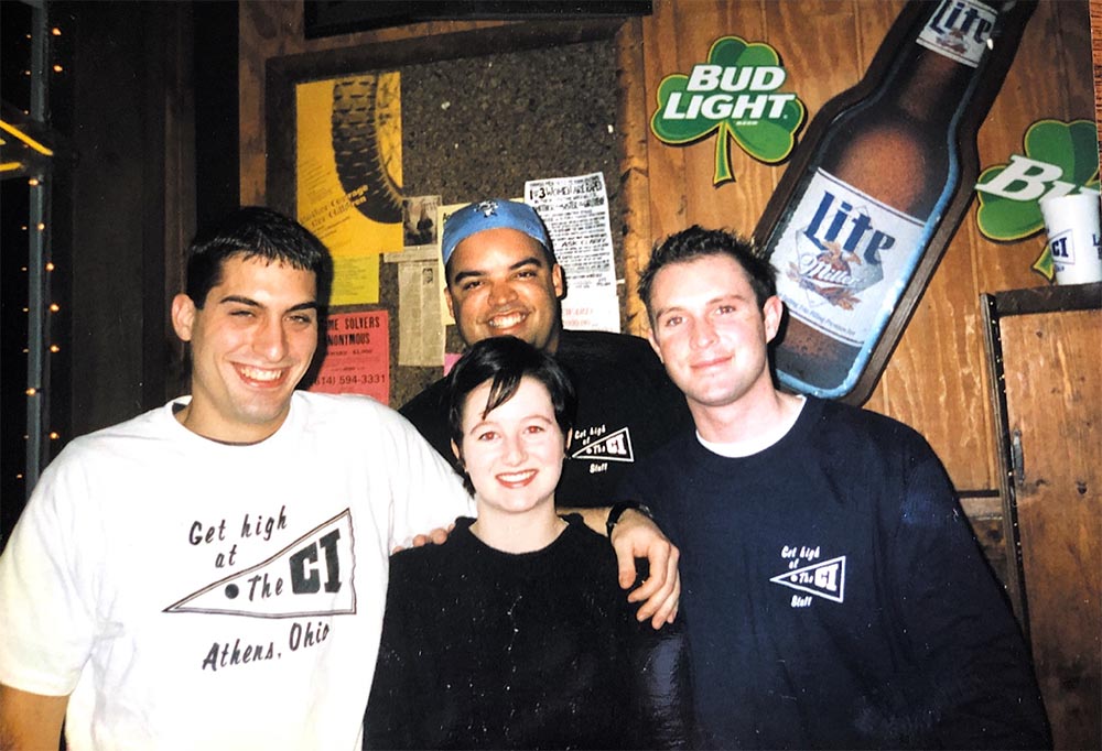 photo of four people near the front door of The CI from early 2000s
