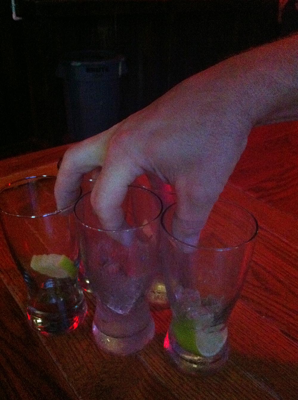 photo of bartender grabbing empty glasses from the bar
